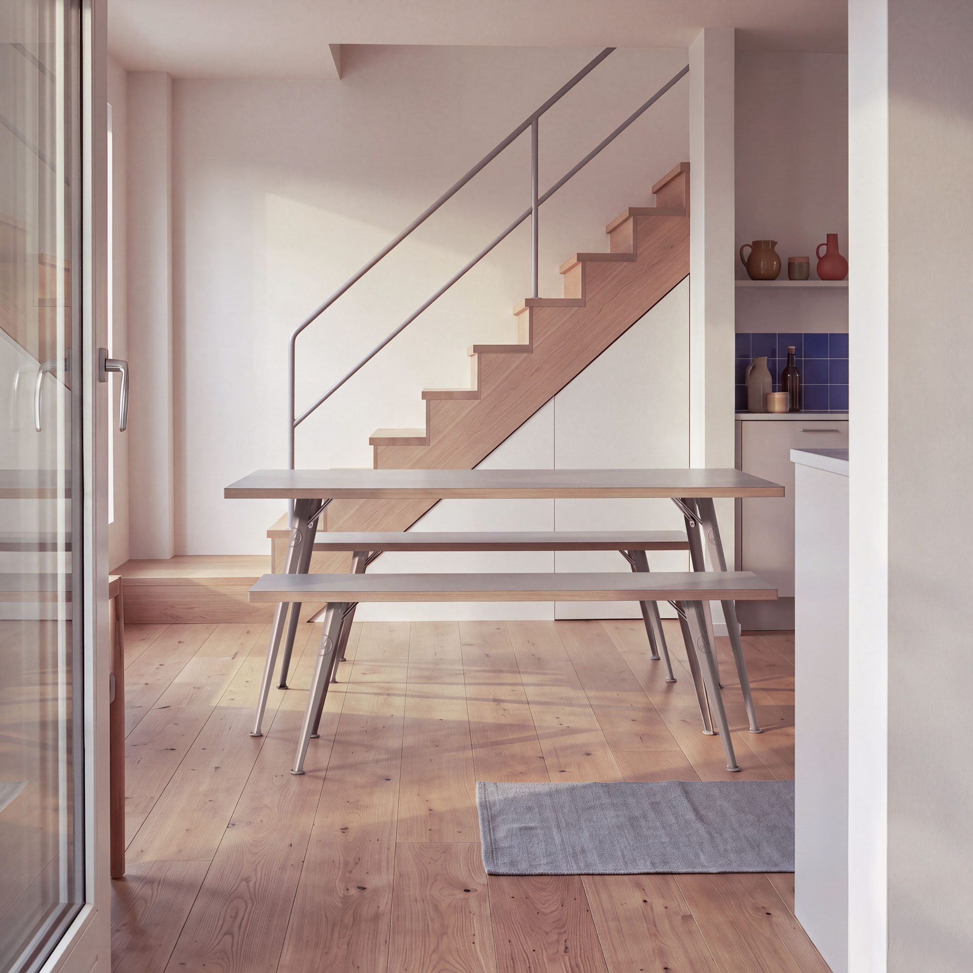 Rowac-Tisch und zwei Bänke in Sonderfarbe Desert Sand auf hellem Holzfußboden in modernem Interieur mit Treppe