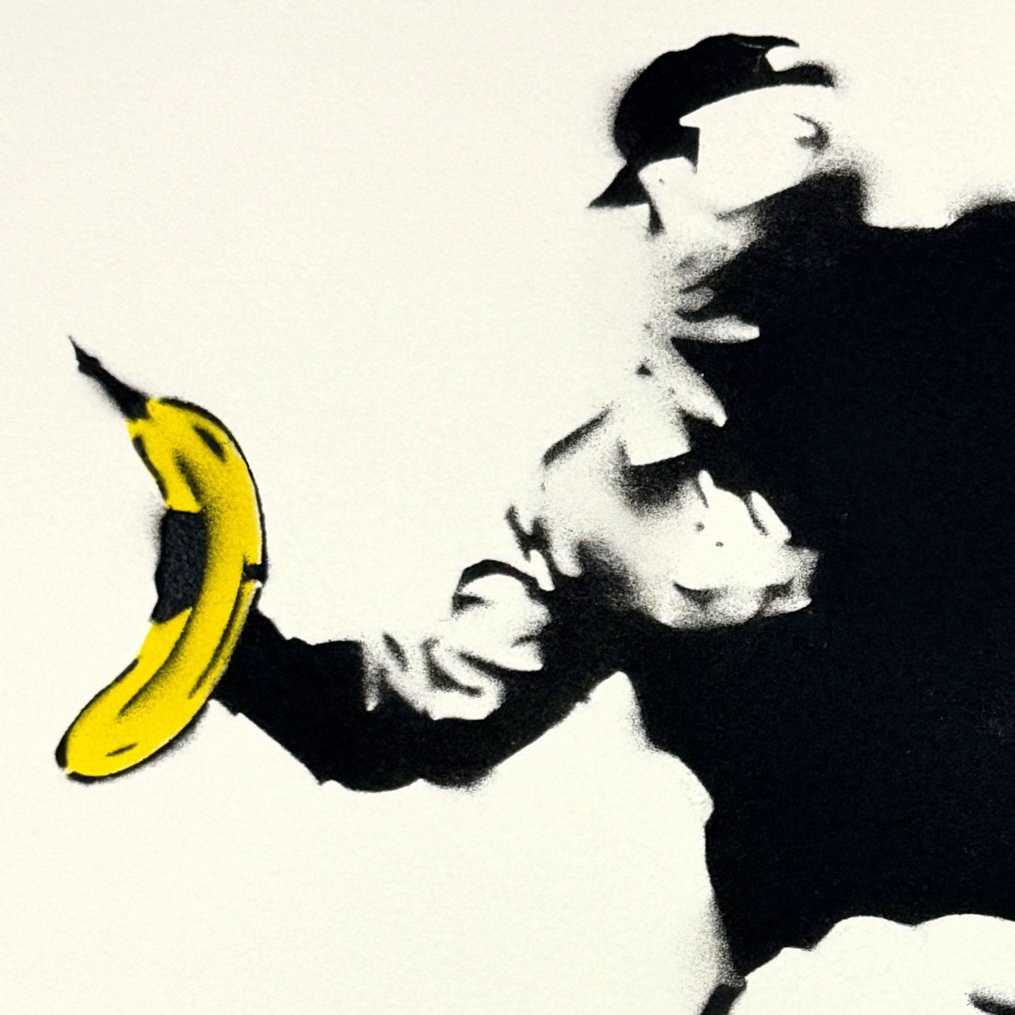 Schablonen-Graffiti eines vermummten Mannes in Schwarz-Weiß, der eine gelbe Banane wirft, Hommage an Banksy
