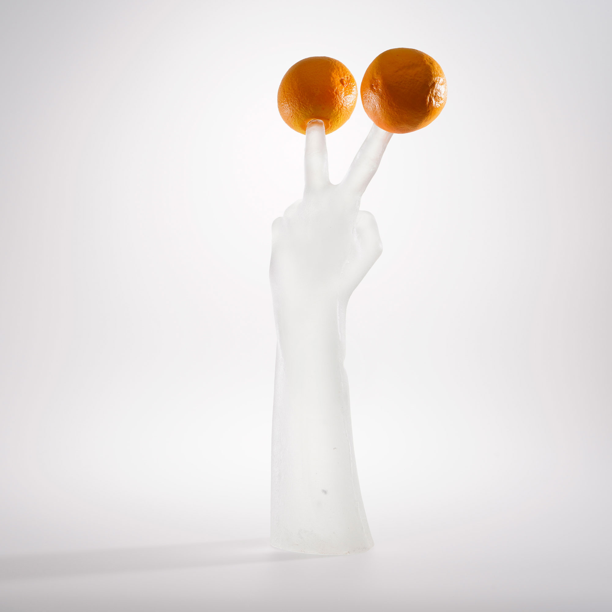 One Minute Sculpture als Glas-Skulptur mit zwei Orangen, freigestellt vor hellem Hintergrund